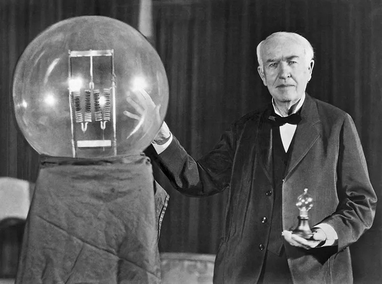 Thomas Edison cầm trên tay bóng đèn sợi đốt tại một bữa tiệc ở New Jersey, Mỹ vào năm 1929. Ảnh: Underwood Archives