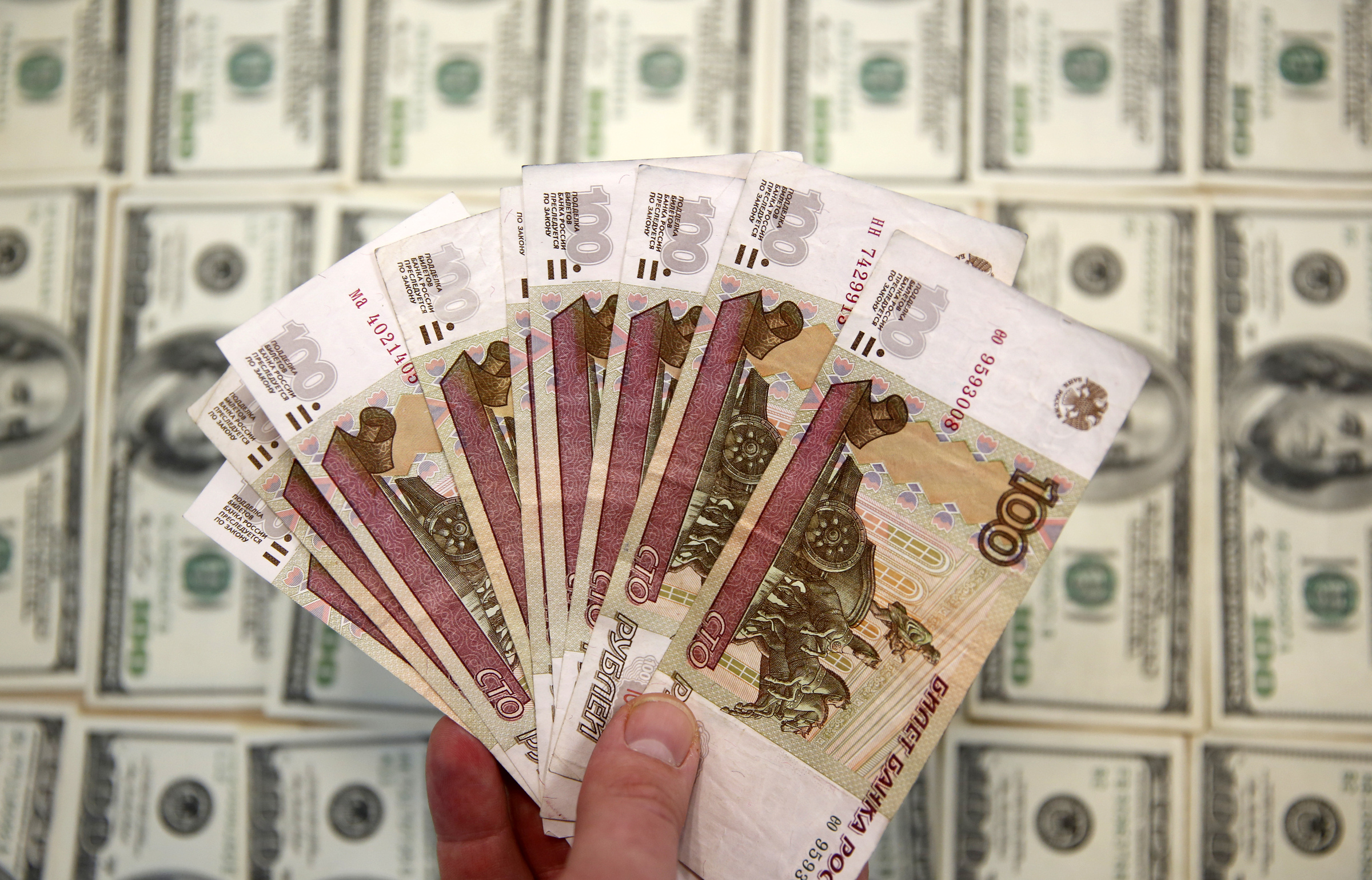 Tiền ruble được chụp trên nền USD. Ảnh: Reuters