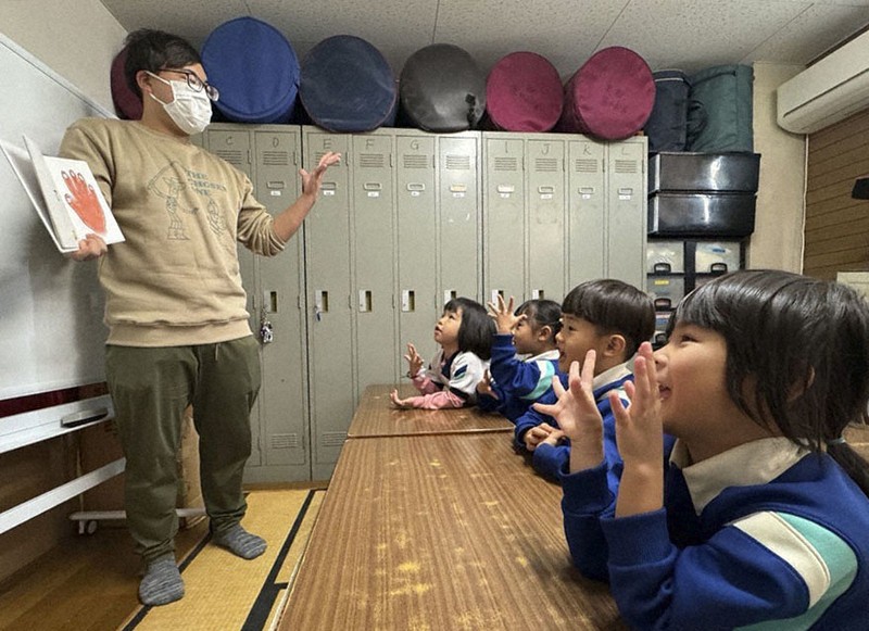 Phó hiệu trưởng Daisuke Hironaka dạy tiếng Nhật cho trẻ mẫu giáo tại trường Ikuno Komorebi ở Osaka. Ảnh: Kyodo