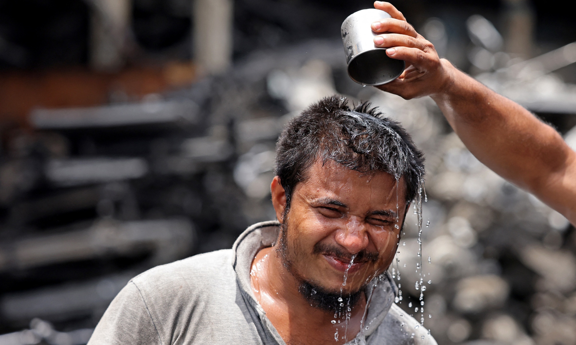 Người đàn ông đổ nước lên đầu để giải nhiệt giữa nắng nóng ở Dubai, UAE, ngày 24/7. Ảnh: AFP