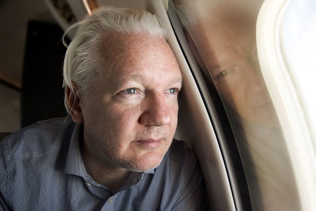Julian Assange nhìn ra cửa sổ máy bay khi từ London tới Bangkok ngày 25/6. Ảnh: AFP
