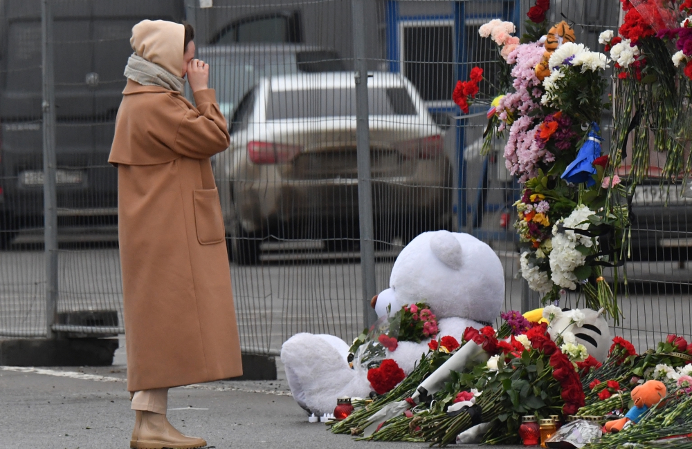Một phụ nữ bật khóc khi tưởng niệm các nạn nhân vụ xả súng, bên ngoài hàng rào chắn quanh hiện trường. Ảnh: AFP