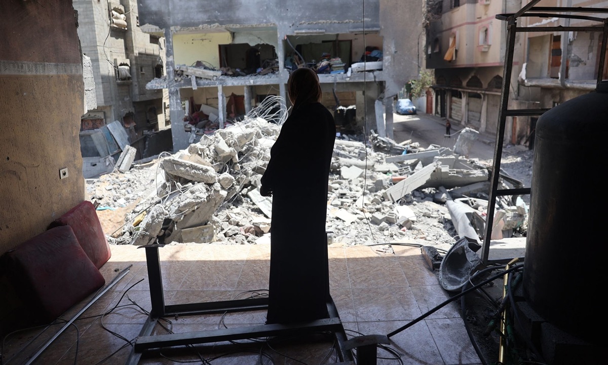 Người phụ nữ đứng nhìn một tòa nhà đổ nát sau cuộc đột kích giải cứu con tin của Israel hôm 8/6. Ảnh: AFP
