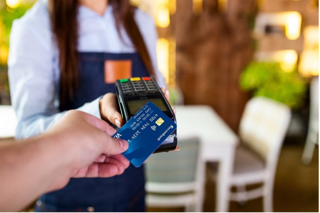 Người dùng thanh toán hàng hóa, dịch vụ qua máy POS với thẻ Sacombank . Ảnh: Sacombank