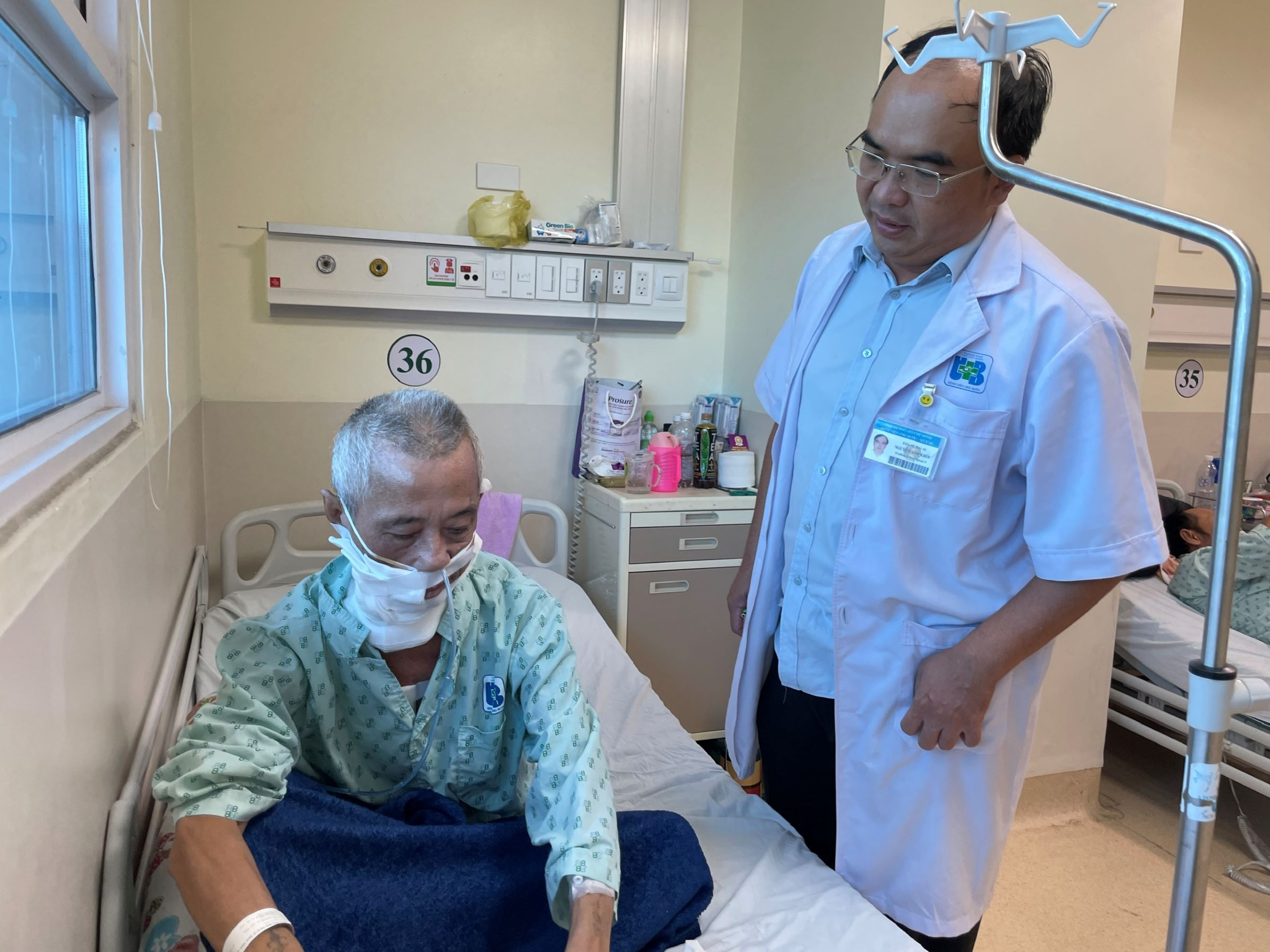 Bác sĩ Nguyễn Anh Khôi hỏi thăm sức khỏe bệnh nhân Lê Thanh Minh sau ca phẫu thuật, sáng 13/9. Ảnh: Hà An