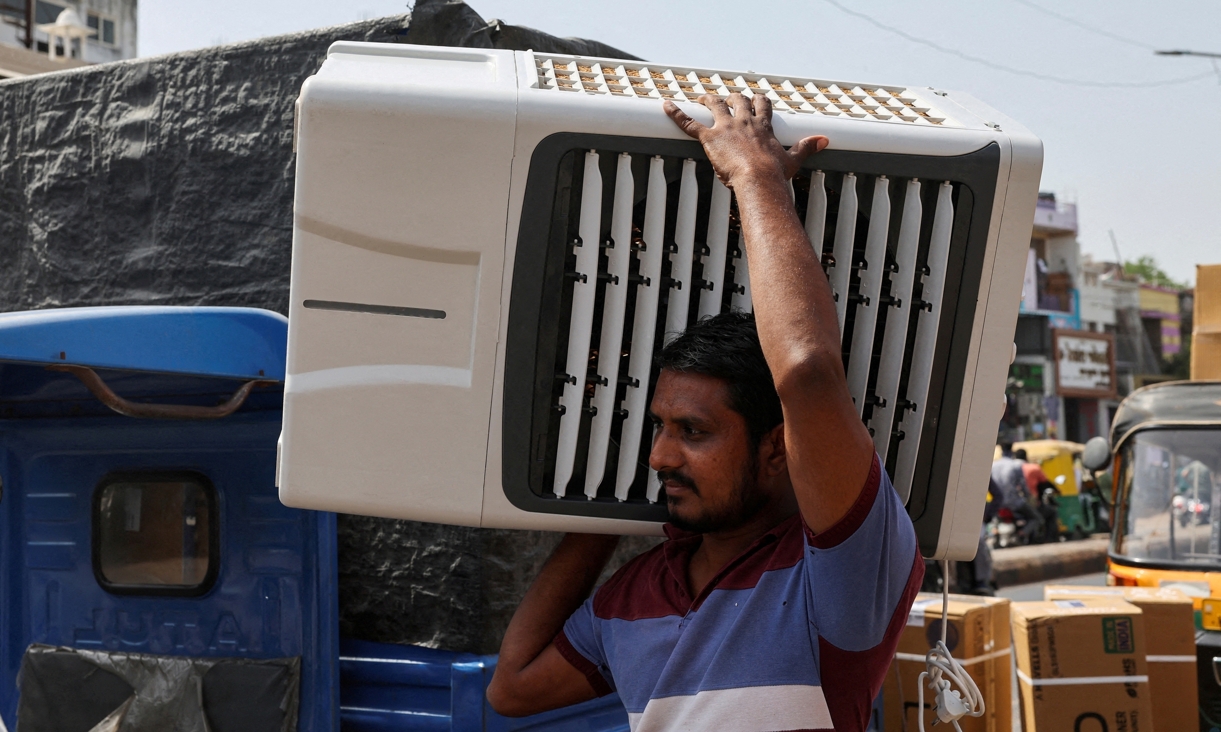 Người đàn ông giao quạt điều hòa cho khách ở Ahmedabad, Ấn Độ, ngày 30/5. Ảnh: Reuters