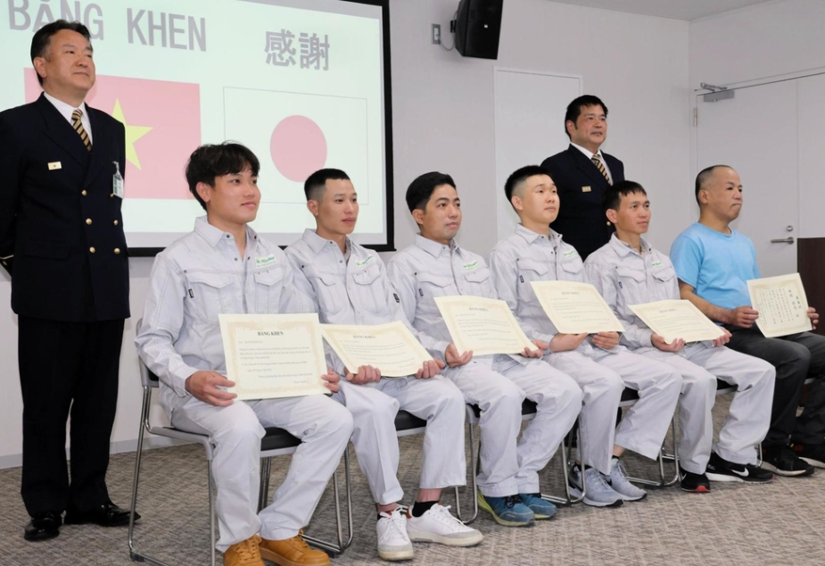 5 lao động Việt Nam (áo ghi) và công nhân Nhật Bản (áo xanh) nhận giấy khen tại cơ quan cứu hỏa tỉnh Hyogo, ngày 19/5. Ảnh: Kobe Shimbun